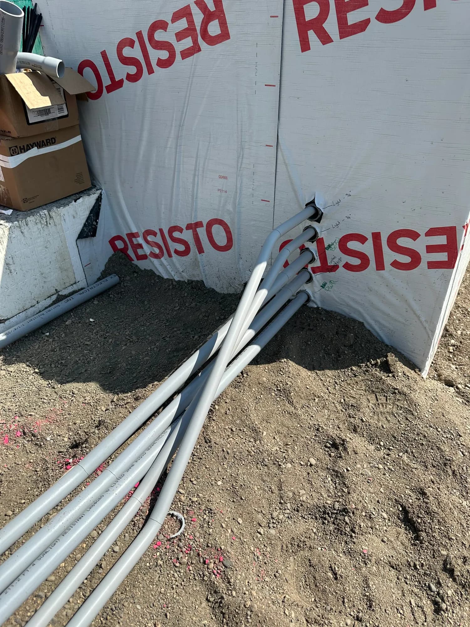 Grey PVC conduit runs at a new build site